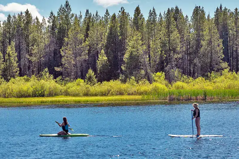 Stand Up paddleboarders on the lake by historic Gilchrist resort near Bend Oregon