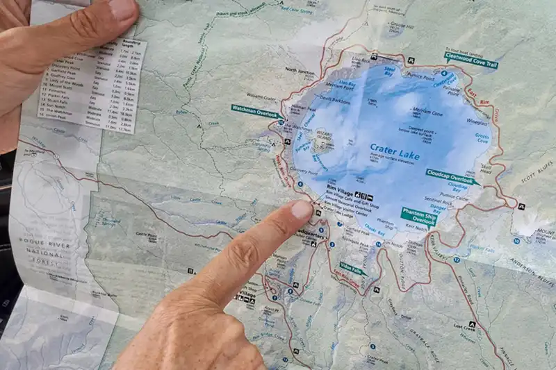 A man pointing at a map showing Crater Lake OR