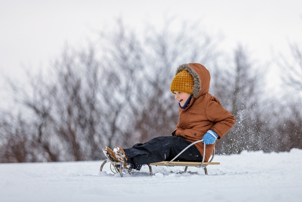 Little boy on sled. Sledding is one of the best things to do in Oregon in winter.